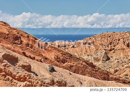 Beautiful landscape of red mountain rocks leading to a blue lake 135724709