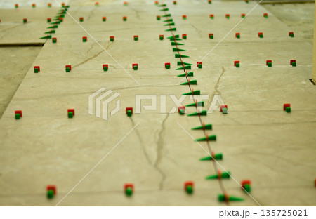 The tile leveling system is a set of special wedges and clamps that allows ceramic tiles to be laid in the same plane without height differences. 135725021