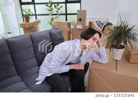 Feeling lost in a new space surrounded by boxes, a person contemplates change and the future in a contemporary office setting Feeling lost in a new space surrounded by boxes, a person contemplates change and the future in a contemporary office setting 135725845