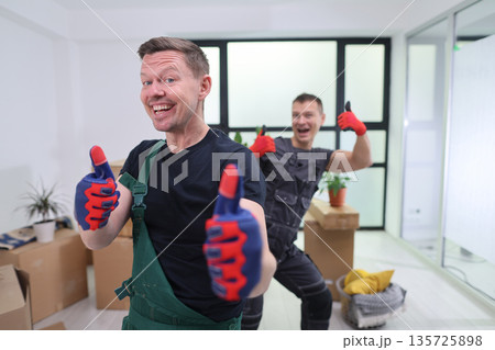Two enthusiastic workers celebrating their progress in a newly renovated office space filled with moving boxes Two enthusiastic workers celebrating their progress in a newly renovated office space filled with moving boxes 135725898