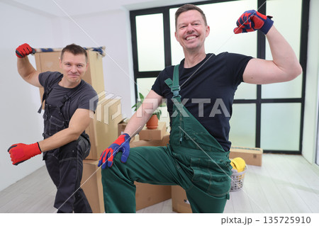 Joyful movers celebrating their hard work in a bright, modern living space filled with boxes 135725910