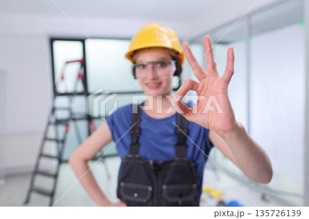 Skilled worker shows approval with a gesture, ready to take on the next construction challenge in a modern building space 135726139