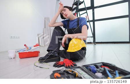 Hardworking individual takes a moment to rest during home renovation on a sunny day in a bright room Hardworking individual takes a moment to rest during home renovation on a sunny day in a bright room 135726149