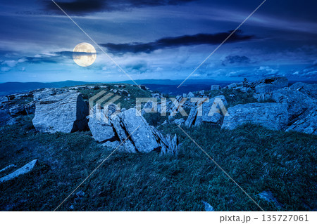 grassy alpine meadow in carpathian mountain landscape at night. sharp rocks and huge boulders among lush grass on rolling hills in full moon light. open space scenery for wanderlust and exploration grassy alpine meadow in carpathian mountain landscape at night. sharp rocks and huge boulders among lush grass on rolling hills in full moon light. open space scenery for wanderlust and exploration 135727061