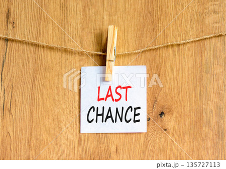 Last chance symbol. Concept word Last chance on beautiful white paper. Beautiful wooden clothespin. Beautiful wooden background. Business last chance concept. Copy space. Last chance symbol. Concept word Last chance on beautiful white paper. Beautiful wooden clothespin. Beautiful wooden background. Business last chance concept. Copy space. 135727113