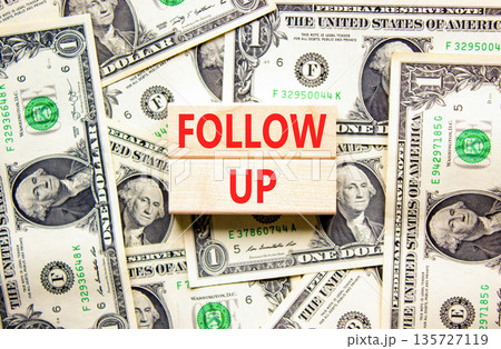 Follow up symbol. Concept word Follow up on beautiful wooden blocks. Dollar bills. Beautiful dollar bills background. Business follow up concept. Copy space. Follow up symbol. Concept word Follow up on beautiful wooden blocks. Dollar bills. Beautiful dollar bills background. Business follow up concept. Copy space. 135727119