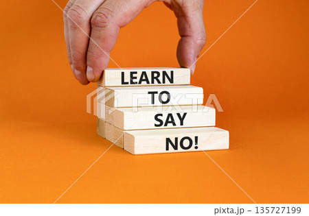 Learn to say no symbol. Concept words phrase Learn to say no on beautiful wooden blocks. Beautiful orange paper background. Businessman's hand Business psychological Learn to say no concept Copy space 135727199