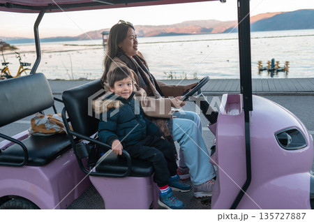 Mother And Son On A Pink Cart By A Beautiful Lakeside View Mother And Son On A Pink Cart By A Beautiful Lakeside View 135727887