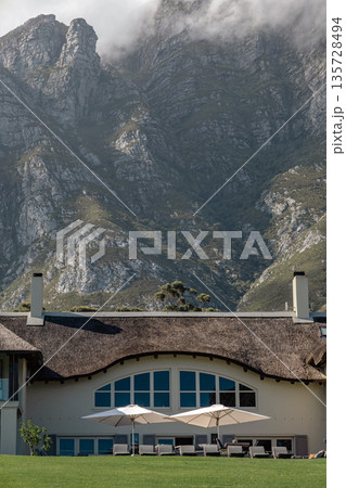 Mountain resort with traditional thatched roof. Luxury travel, natural landscape Mountain resort with traditional thatched roof. Luxury travel, natural landscape 135728494
