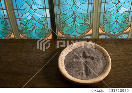 Ash wednesday ashes forming cross in bowl 135728929