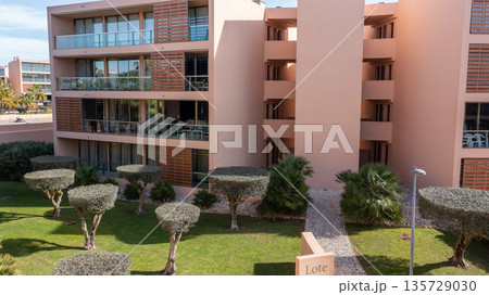 Modern buildings surrounded by landscaped greenery and a path. The location is in Albufeira, Salgados, Algarve, Portugal, captured from above 135729030