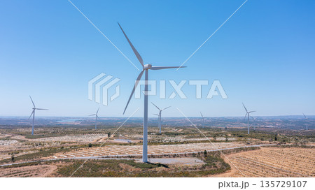 Wind green energy. Wind turbines standing tall in a vast landscape, showcasing renewable energy generation and the promise of a sustainable future Wind green energy. Wind turbines standing tall in a vast landscape, showcasing renewable energy generation and the promise of a sustainable future 135729107