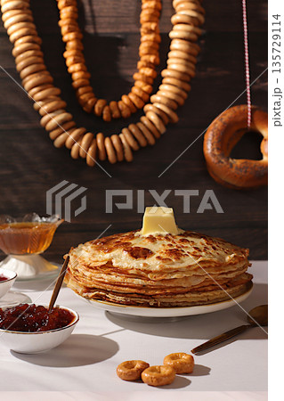 Maslenitsa concept and traditional Russian cuisine.Delicious Russian pancakes with soft cheese, honey, jam, sour cream, caviar and bagels, pretzels on the festive table.Advertising banner for cafe Maslenitsa concept and traditional Russian cuisine.Delicious Russian pancakes with soft cheese, honey, jam, sour cream, caviar and bagels, pretzels on the festive table.Advertising banner for cafe 135729114