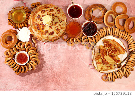 Maslenitsa banner with delicious pancakes with soft cheese,honey, jam,sour cream, caviar and bagels, pretzels on the festive table, concept of traditional Russian cuisine.Promotional menu for cafe Maslenitsa banner with delicious pancakes with soft cheese,honey, jam,sour cream, caviar and bagels, pretzels on the festive table, concept of traditional Russian cuisine.Promotional menu for cafe 135729118