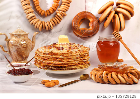 Maslenitsa concept and traditional Russian cuisine.Delicious Russian pancakes with soft cheese, honey, jam, sour cream, caviar and bagels, pretzels on the festive table.Advertising banner for cafe Maslenitsa concept and traditional Russian cuisine.Delicious Russian pancakes with soft cheese, honey, jam, sour cream, caviar and bagels, pretzels on the festive table.Advertising banner for cafe 135729129