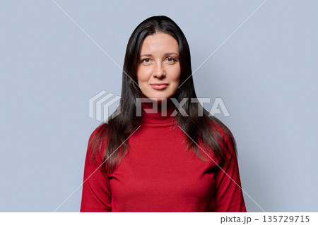 Portrait of beautiful smiling 40 years old woman posing on light gray background 135729715