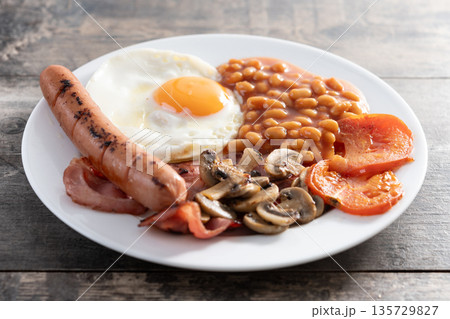 Full English breakfast with fried egg, bacon, sausages and beans Full English breakfast with fried egg, bacon, sausages and beans 135729827