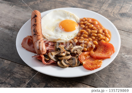 Full English breakfast with fried egg, bacon, sausages and beans Full English breakfast with fried egg, bacon, sausages and beans 135729869