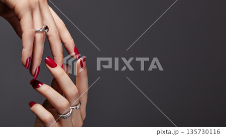 Luxury glamour photograph of elegant female hands with deep burgundy manicure on gray background. Long square nails with dark red gel polish. Fashionable luxury style with brilliant jewelry rings Luxury glamour photograph of elegant female hands with deep burgundy manicure on gray background. Long square nails with dark red gel polish. Fashionable luxury style with brilliant jewelry rings 135730116