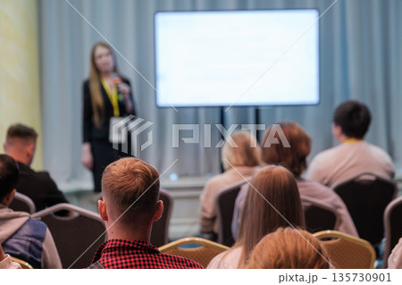Professional conference presentation with speaker and audience in a bright meeting room 135730901