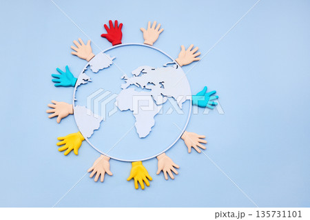 Diverse hands embracing earth globe representing global unity 135731101