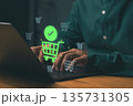 Person using laptop for online shopping with glowing cart icons, representing e-commerce, digital payment, and internet retail. Concept of secure online transaction and modern consumer behavior. 135731305