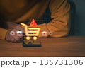 Person using smartphone with digital shopping cart and warning icons, symbolizing online shopping fraud, e-commerce scam, and payment risk. Concept of cybersecurity and consumer protection awareness. 135731306
