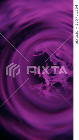 Paint drop defocused. Smoke whirl. Color fume blob drop floating in round frame on black background. Neon purple glow abstract swirl. Paint drop defocused. Smoke whirl. Color fume blob drop floating in round frame on black background. Neon purple glow abstract swirl. 135731364