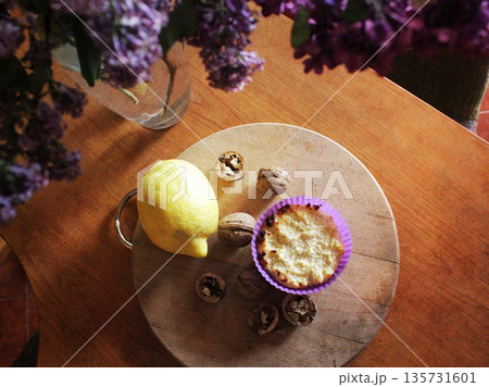 A home-baked tart with lemon and walnuts on a round wooden board. Candid, cozy scene is perfect for food and lifestyle content. Rustic food. A home-baked tart with lemon and walnuts on a round wooden board. Candid, cozy scene is perfect for food and lifestyle content. Rustic food. 135731601