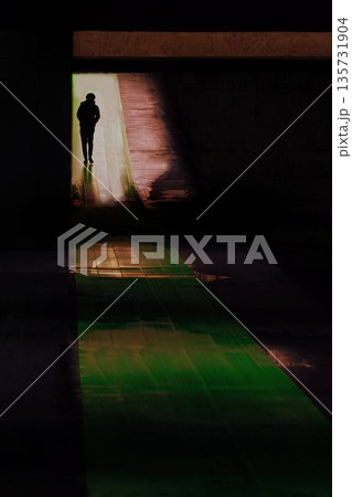 アンダーパスの暗闇の中を歩く人 135731904
