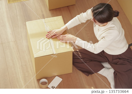 引越しの荷物整理をする若い女性 135733664