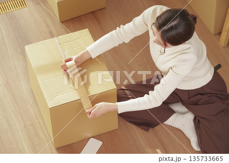 引越しの荷物整理をする若い女性 135733665