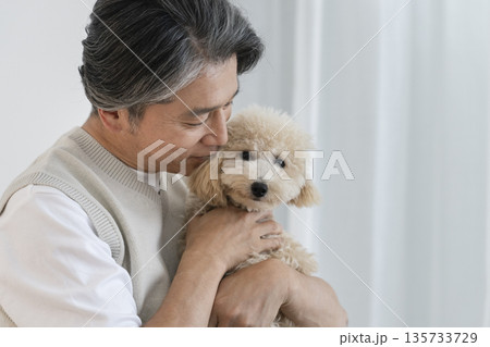 愛犬を抱く中高年男性　犬との暮らしイメージ 135733729