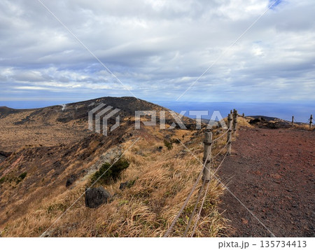 伊豆大島・三原山でトレッキング中に見られる噴気を伴う火口の風景 伊豆大島・三原山でトレッキング中に見られる噴気を伴う火口の風景 135734413