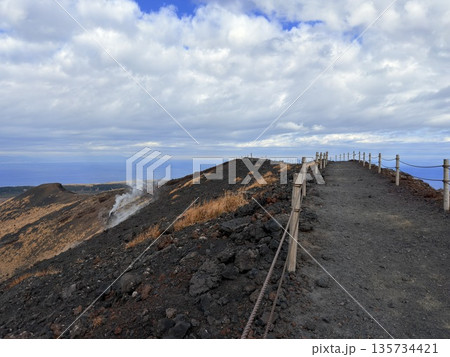 伊豆大島・三原山でトレッキング中に見られる噴気を伴う火口の風景 135734421