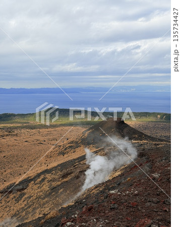 伊豆大島・三原山でトレッキング中に見られる噴気を伴う火口の風景 135734427