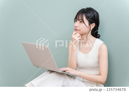 パソコンを見ながら真剣な表情で考える若いアジア人女性 パソコンを見ながら真剣な表情で考える若いアジア人女性 135734678