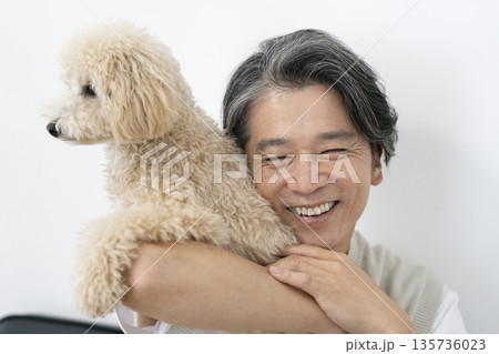 愛犬を抱く笑顔の50代の男性 犬との暮らしイメージ 愛犬を抱く笑顔の50代の男性 犬との暮らしイメージ 135736023