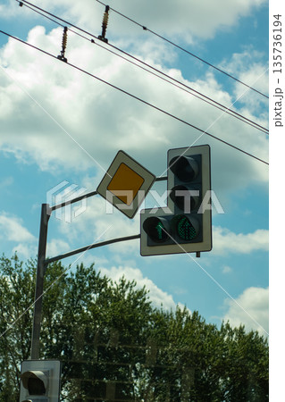 Spacious daytime street view showcasing safety signs beside trees and electrical wires 135736194