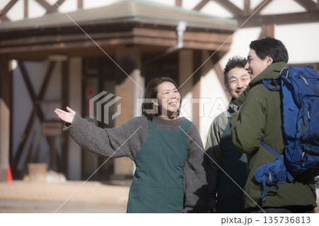 田舎で民宿やペンションを家族経営している接客や受付、チェックインの案内する夫婦と登山者 135736813
