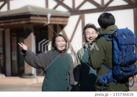 田舎で民宿やペンションを家族経営している接客や受付、チェックインの案内する夫婦と登山者　登山の山小屋 135736816