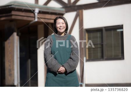地方移住で田舎で民宿やペンション、カフェを家族経営している女性のイメージ全身　カメラ目線 135736820