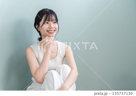 頬杖をつく美肌の笑顔のアジア人女性（美容・エステ・スキンケアイメージ） 135737130