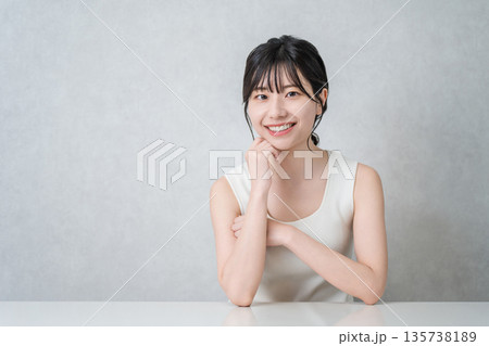 頬杖をつく美肌の笑顔のアジア人女性（美容・エステ・スキンケアイメージ） 135738189