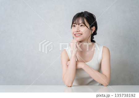 頬杖をつく美肌の笑顔のアジア人女性(美容・エステ・スキンケアイメージ) 頬杖をつく美肌の笑顔のアジア人女性(美容・エステ・スキンケアイメージ) 135738192