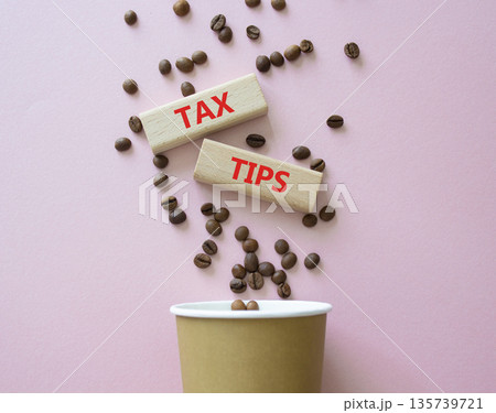 Tax Tips symbol. Wooden blocks with words Tax Tips. Beautiful pink background with coffee cup and coffee beans. Business and Tax Tips concept. Copy space. Tax Tips symbol. Wooden blocks with words Tax Tips. Beautiful pink background with coffee cup and coffee beans. Business and Tax Tips concept. Copy space. 135739721