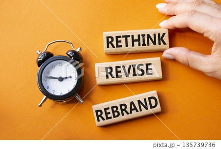 Rethink Revise Rebrand symbol. Wooden blocks with words Rethink Revise Rebrand. Businessman hand. Beautiful orange background with alarm clock. Business and Rethink Revise Rebrand concept. Copy space. Rethink Revise Rebrand symbol. Wooden blocks with words Rethink Revise Rebrand. Businessman hand. Beautiful orange background with alarm clock. Business and Rethink Revise Rebrand concept. Copy space. 135739736