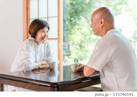 新緑の見える和室でお茶を飲むシニア夫婦(お茶の時間,旅館,和室,居間) 新緑の見える和室でお茶を飲むシニア夫婦(お茶の時間,旅館,和室,居間) 135740541