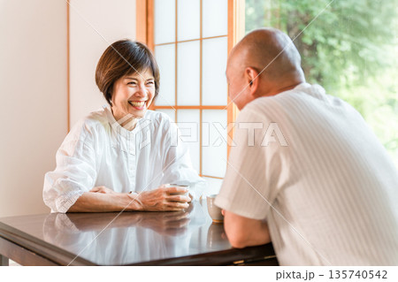新緑の見える和室でお茶を飲むシニア夫婦(お茶の時間,旅館,和室,居間） 135740542