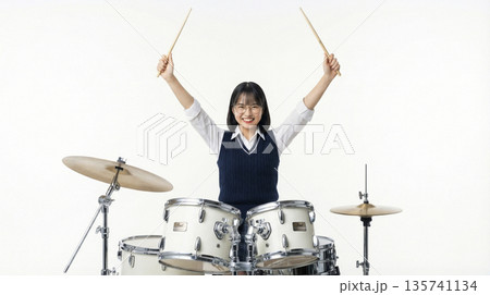 笑顔でスティックを掲げる女子高生ドラマーの達成感 135741134